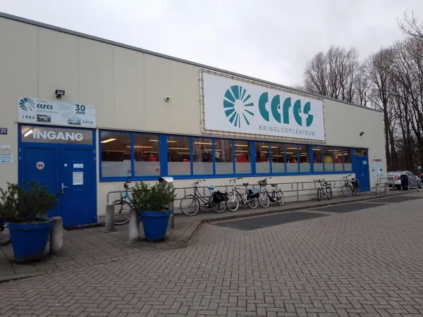 Voorgevel van kringloopwinkel Ceres met blauwe ingang, logo en fietsenrek