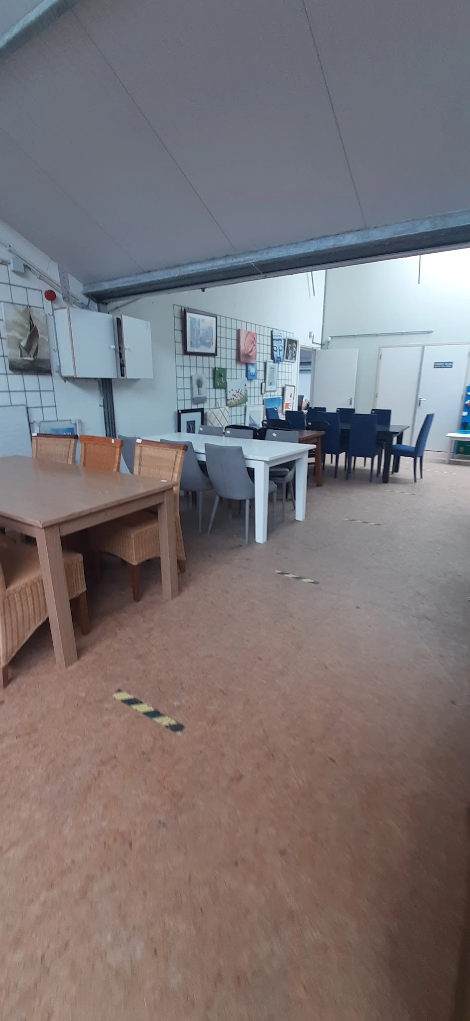 Winkelvloer met uitgestalde meubels: houten tafels en stoelen in verschillende kleuren