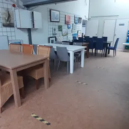 Winkelvloer met uitgestalde meubels: houten tafels en stoelen in verschillende kleuren