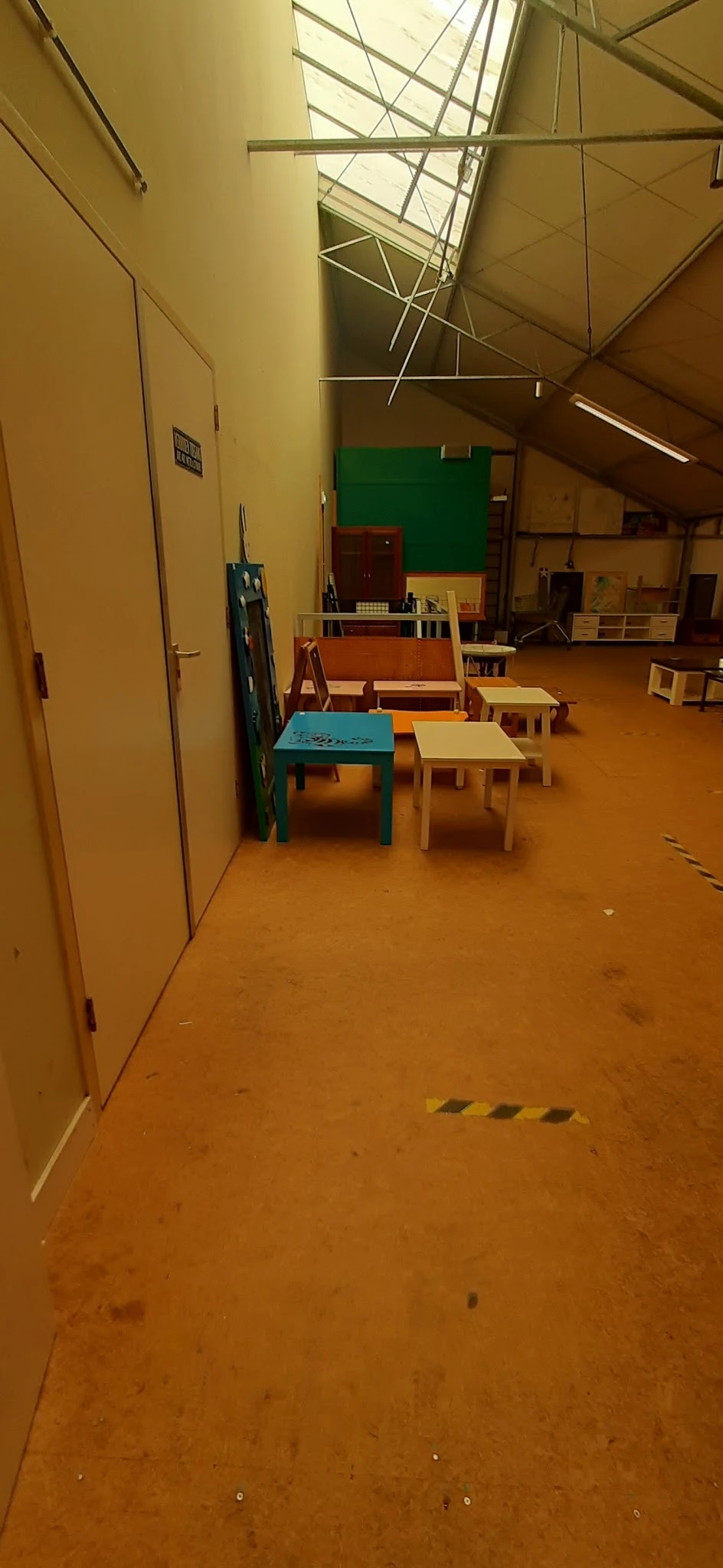 Kinderafdeling met speeltafel, kleine stoeltjes en speelgoed in een kringloopwinkel