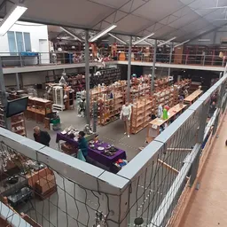 Overzicht van de winkelvloer met kartonnen dozen en stellingen, bezoekers winkelen tussen het aanbod