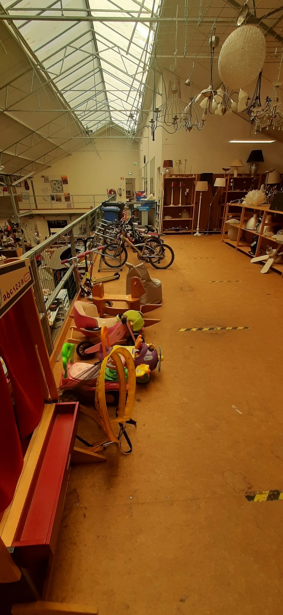 Kindervoertuigen en fietsen uitgestald in een kringloopwinkel