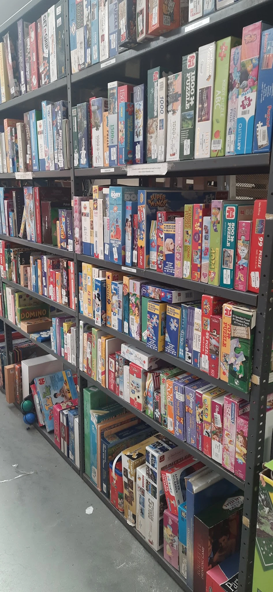 Stellingen vol met gezelschapsspelen en puzzels in verschillende kleuren en formaten