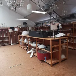 Winkelvloer met houten stellingen, tafels met witte decoratieve items en lampen, fluorescente verlichting aan het plafond
