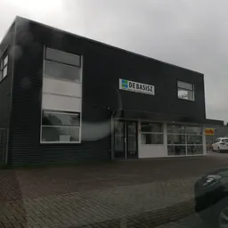 Moderne gevel van kringloopwinkel De Basisz met grote ramen en zwarte gevelbekleding