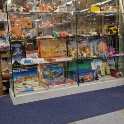 Vitrinekast met tentoongestelde speelgoed, bouwsets en action figures in een kringloopwinkel