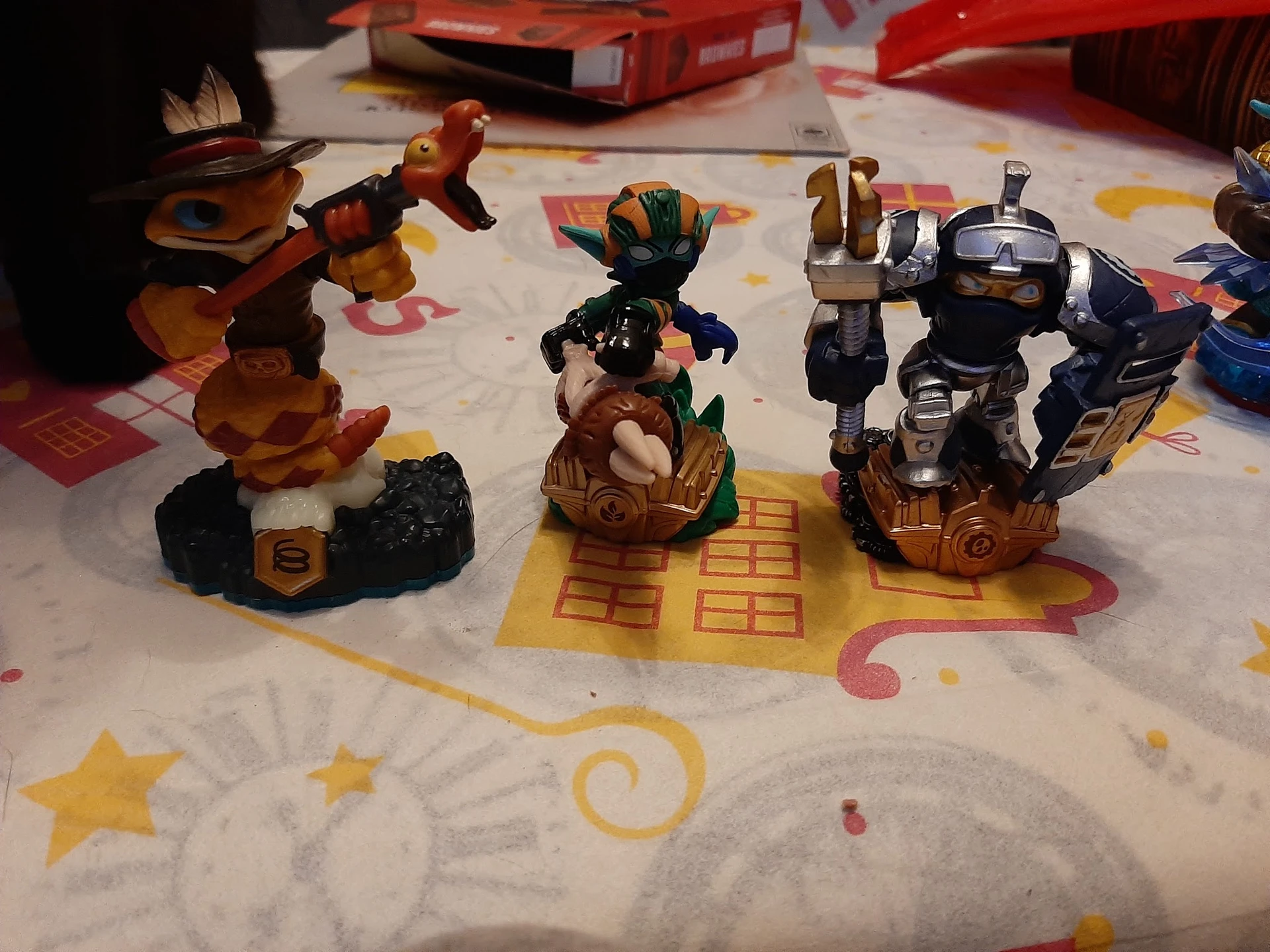 Drie verzamelfiguren van actiespelletjes op een kinderkleed