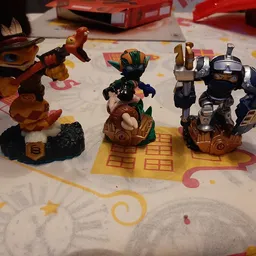 Drie verzamelfiguren van actiespelletjes op een kinderkleed