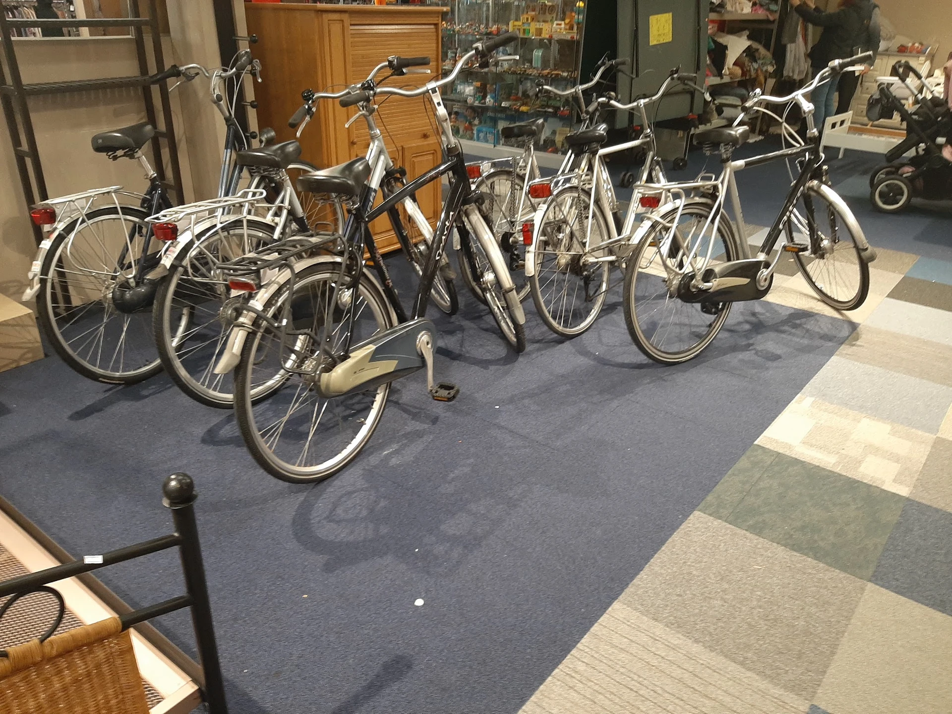Rij met tweedehands fietsen in diverse kleuren en stijlen op de winkelvloer
