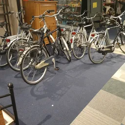 Rij met tweedehands fietsen in diverse kleuren en stijlen op de winkelvloer