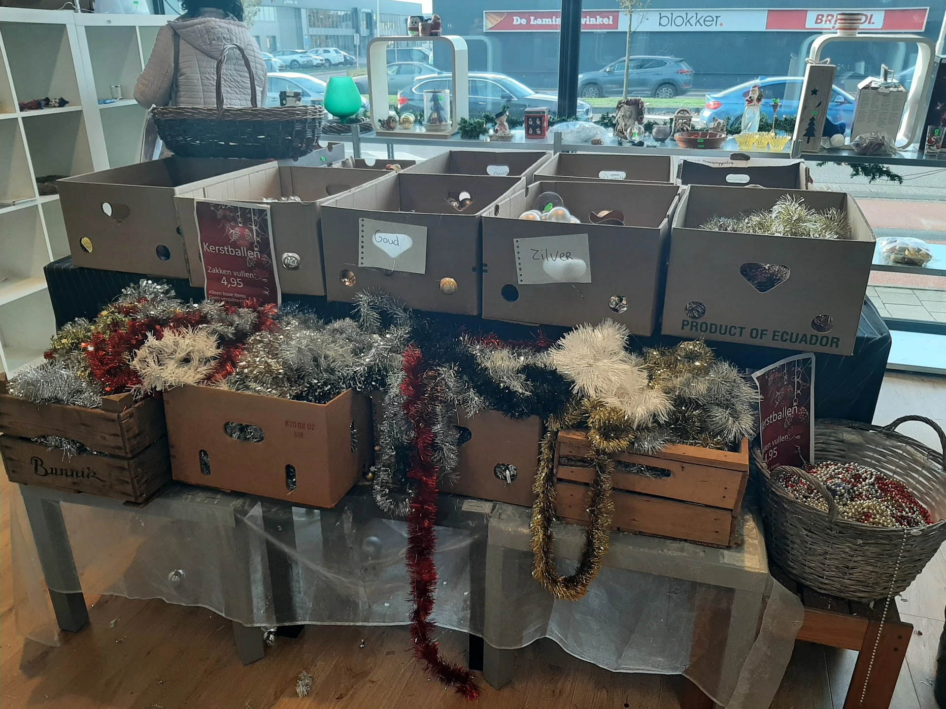 Uitstalling van decoratieve items: koffers versierd met kunstbloemen en slingers op een tafel in de winkel