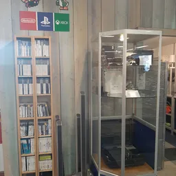 Kast met dvd's en cd's naast vitrinekast met elektronica in kringloopwinkel