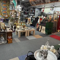 Winkelvloer van kringloopwinkel met diverse uitgestalde huisraad, meubels en decoratieve artikelen