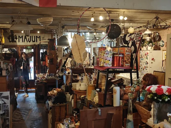 Winkelvloer met diverse gebruikte meubels, lampen, decoratie en huishoudartikelen uitgestald in een kringloopwinkel