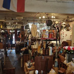 Winkelvloer met diverse gebruikte meubels, lampen, decoratie en huishoudartikelen uitgestald in een kringloopwinkel