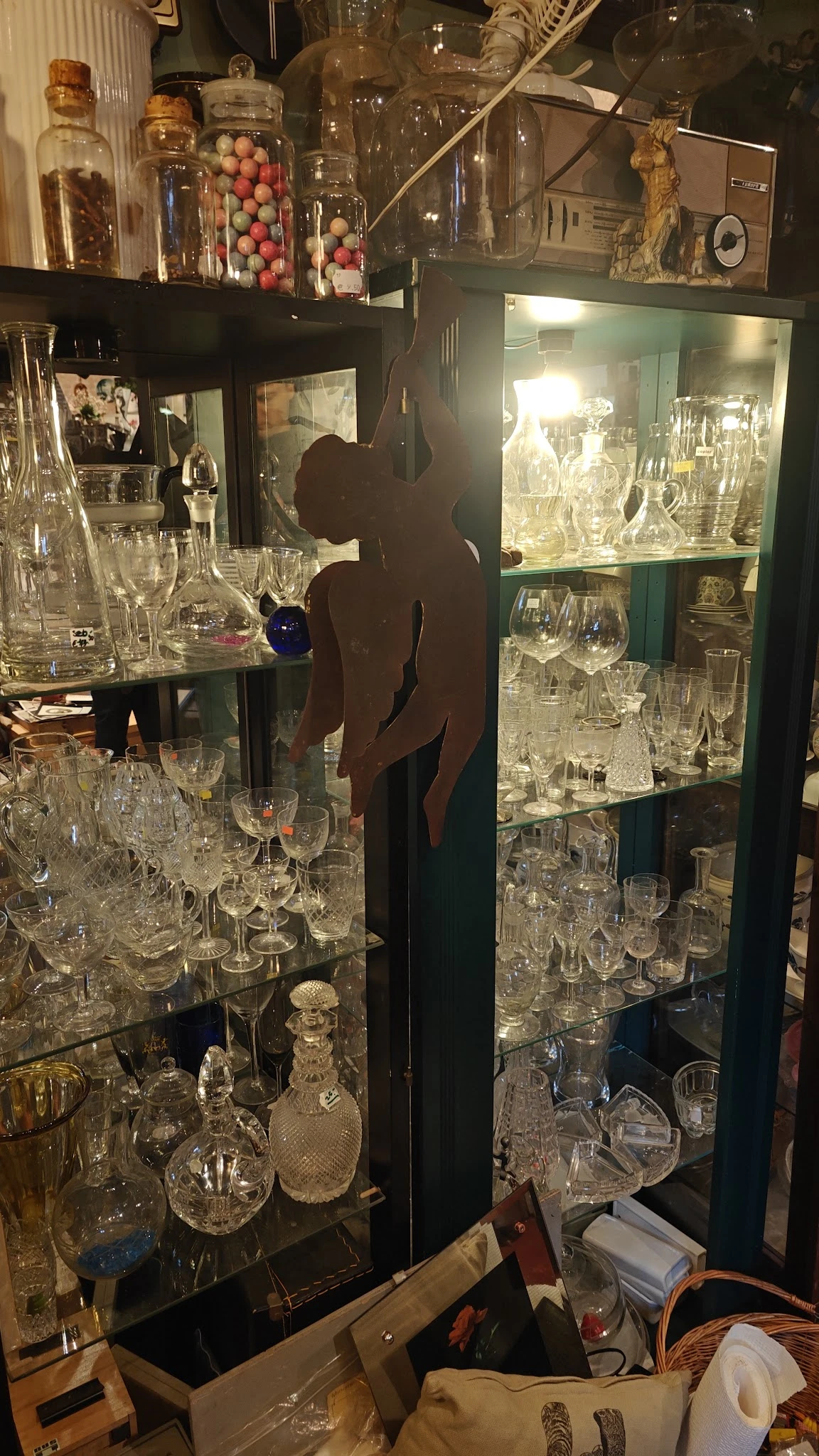 Glazen vitrinekast met uitgestalde kristallen glazen, bokalen en andere glaswerk