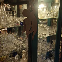 Glazen vitrinekast met uitgestalde kristallen glazen, bokalen en andere glaswerk