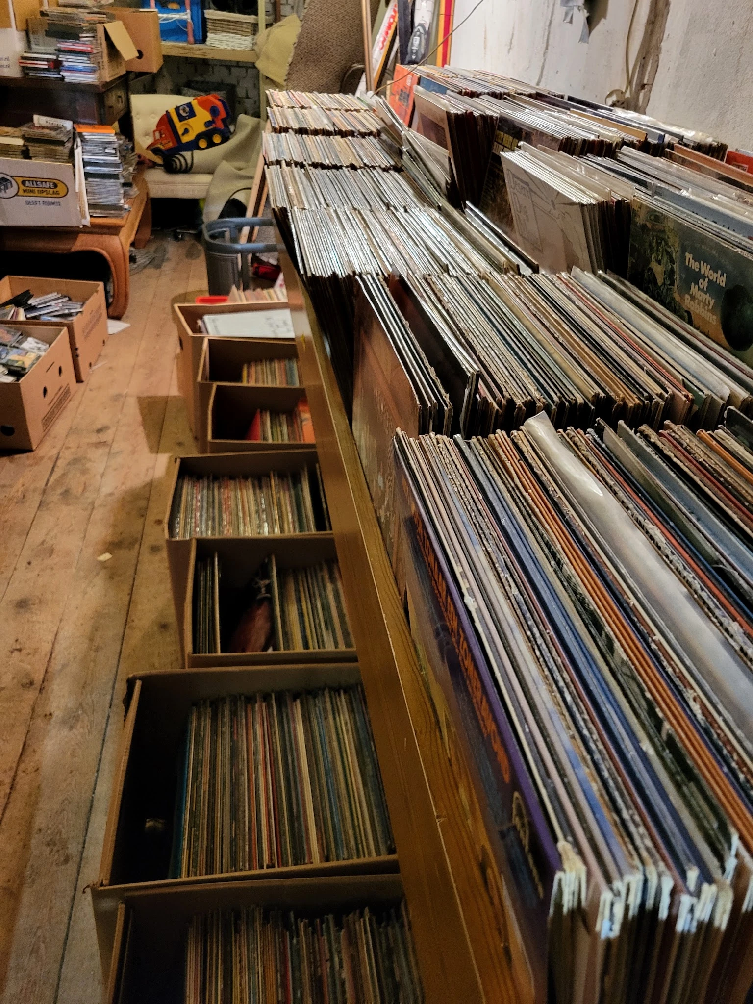 Uitgebreide verzameling vinyl records en cd's in houten stellingen en opbergkisten
