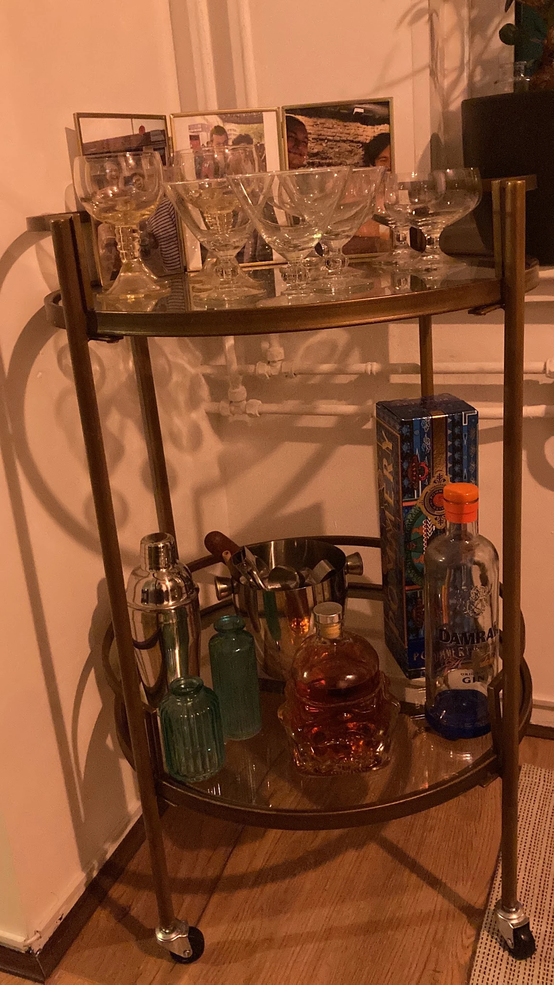 Glazen vitrinekast met flesjes sterkedrank en vintage baruitrusting zoals shakers en jiggers