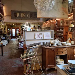 Winkelvloer van kringloopwinkel met diverse meubels, servies, decoratie en vintage spullen uitgestald