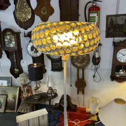 Goudkleurige hanglamp met ronde glazen bolletjes in vintage stijl, hangend in de winkel.