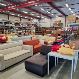 Winkelvloer met diverse meubels: banken, stoelen, tafels en ander huisraad; stellingen en opslag op de achtergrond