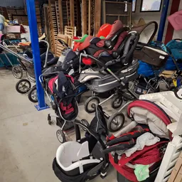 Verzameling tweedehands kinderwagens en buggy's in een opslagruimte