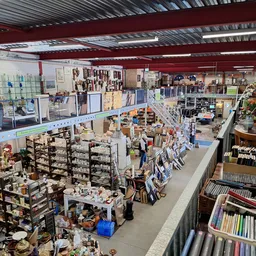 Overzicht van de winkelvloer met diverse stellingen, rekken met spullen en afdelingen in een kringloopwinkel
