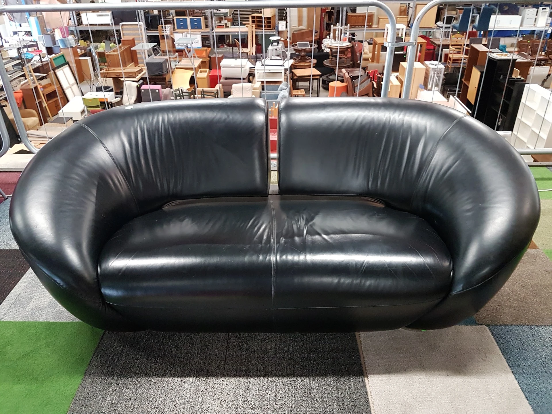 Zwarte leren designbank met ronde vormen in kringloopwinkel