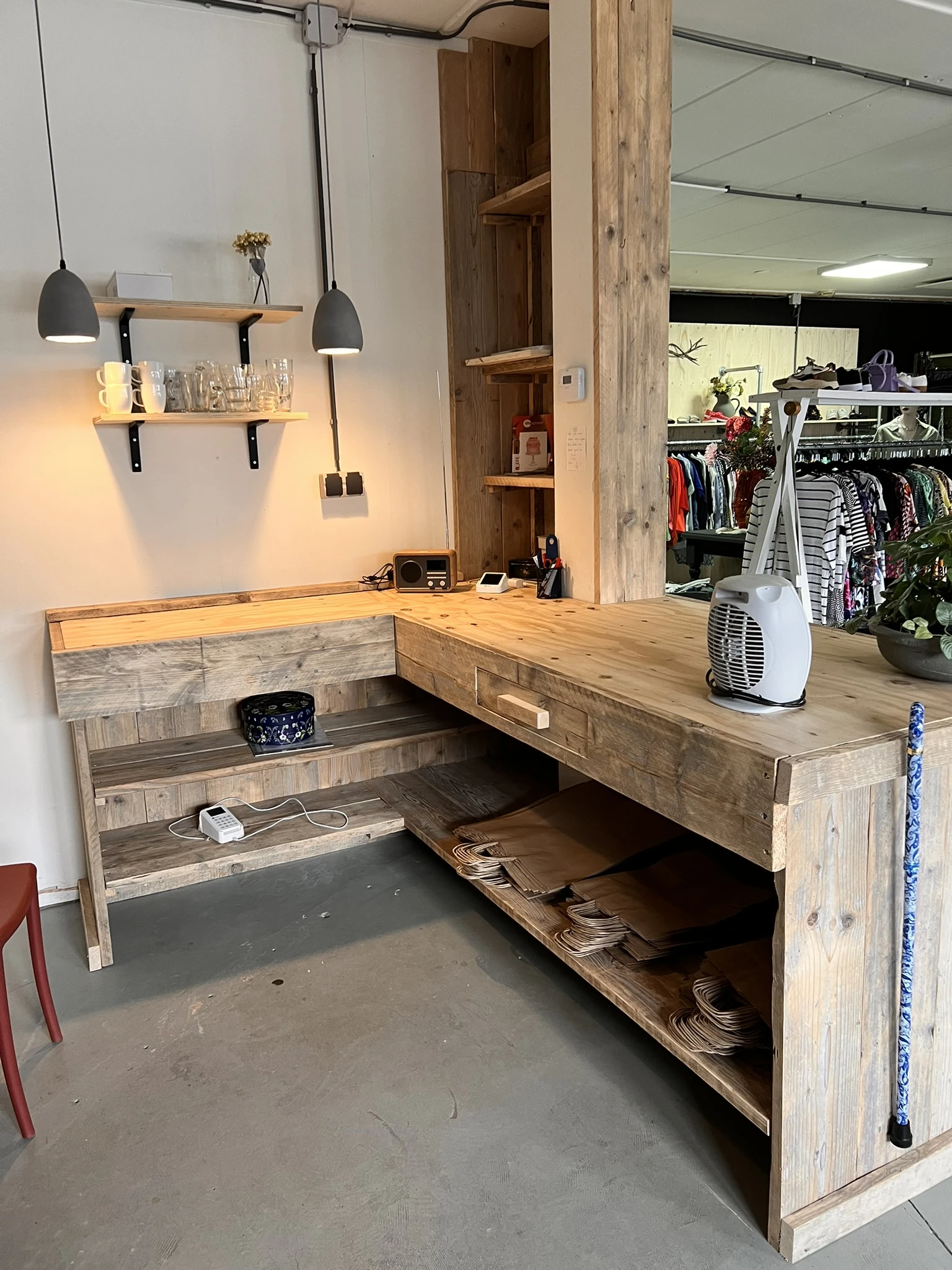 Houten bureautafel met lades en open kasten, met lampen, planken en diverse items erop