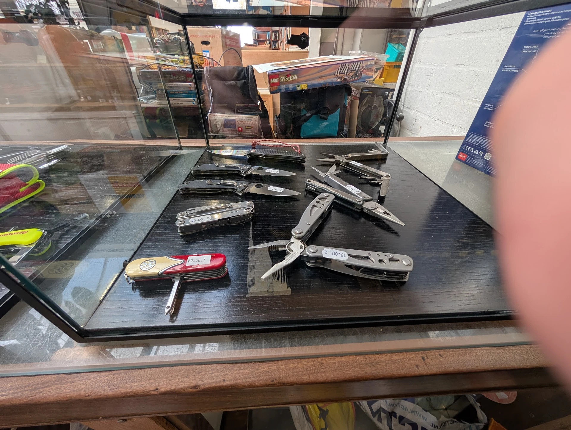 Verzameling van verschillende vouwmessen en zakmes uitgestald op een zwarte tafel in de winkel