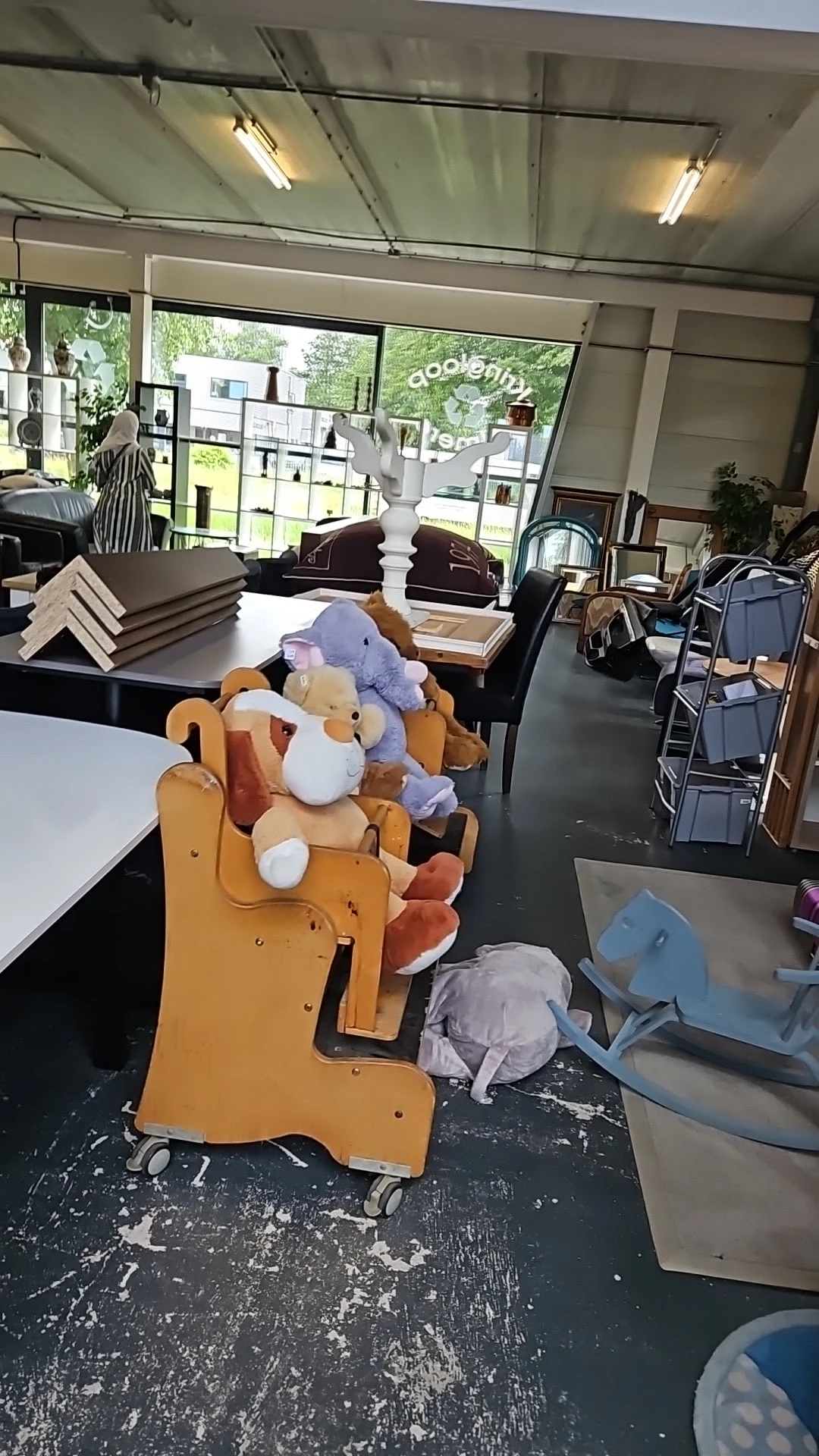 Knuffels en pluchen dieren gestapeld op een oranje stoel in de winkel
