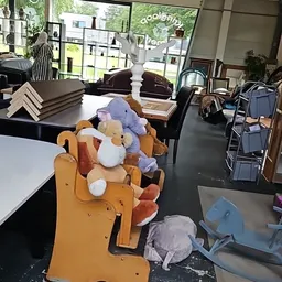 Knuffels en pluchen dieren gestapeld op een oranje stoel in de winkel