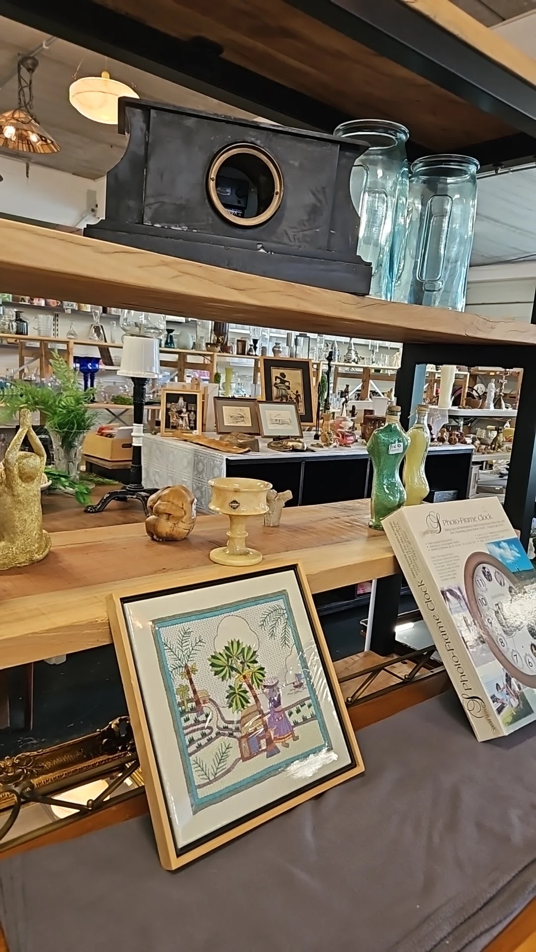 Houten toonbank met decoratieve objecten, foto's en huishoudartikelen in een kringloopwinkel