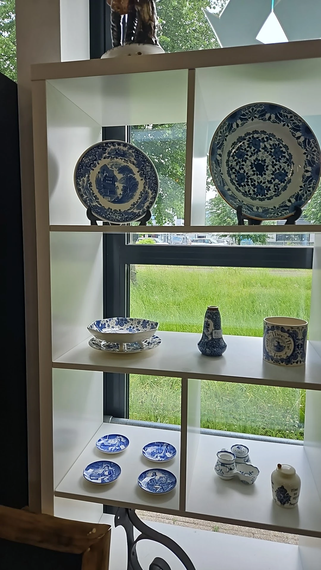 Blauw-wit porselein servies en decoratieve objecten op een vensterbank.