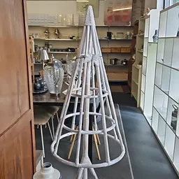 Witte metalen paralustandaard in conische vorm in een kringloopwinkel