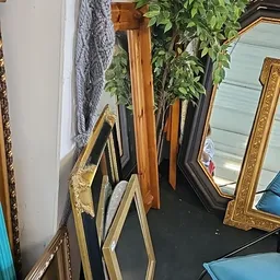 Diverse spiegels in verschillende frames en maten tegen de muur gestapeld