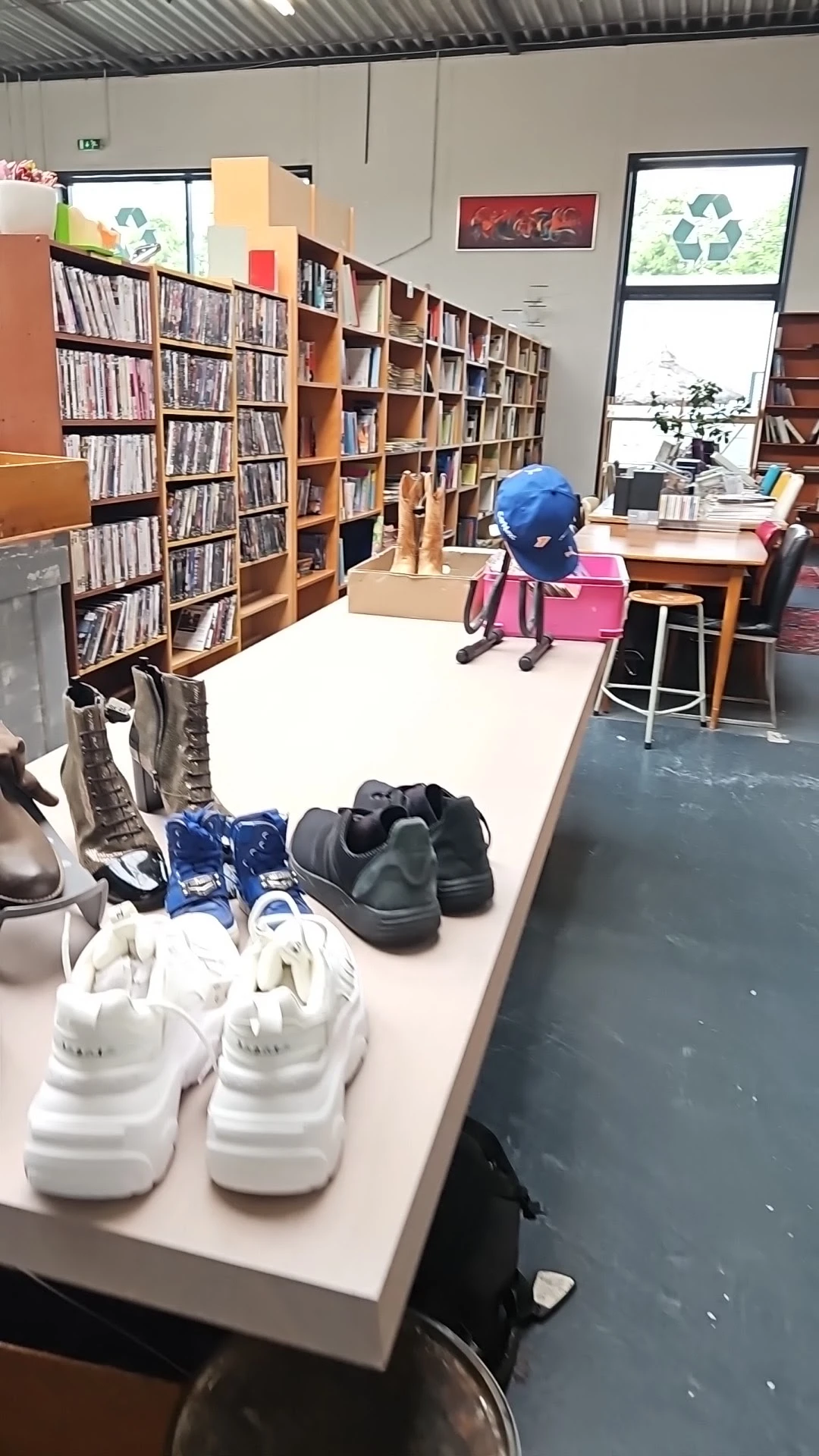 Tafel met uitgestalde tweedehands schoenen en laarzen in diverse kleuren en stijlen