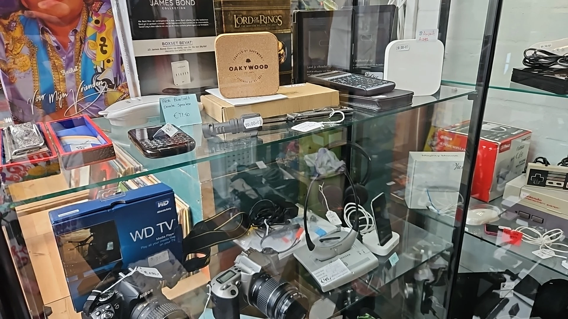 Glazen vitrine met elektronische apparaten, camera's en accessoires uitgestald