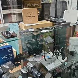 Glazen vitrine met elektronische apparaten, camera's en accessoires uitgestald
