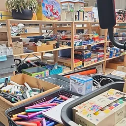 Werkplekken met houten opbergkastjes vol doos- en potloden, kantoorbenodigdheden en diverse spullen