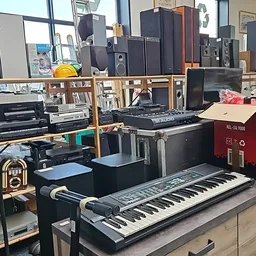 Werkstation met keyboards, synthesizers, speakers en muziekequipment in verschillende formaten