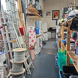 Winkelvloer met stellingen, rekken met kleding en huishoudartikelen, overzicht van het warenaanbod