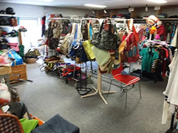 Kringloopwinkel met kledingrekken, mannequins en diverse tweedehands kleding op hangers