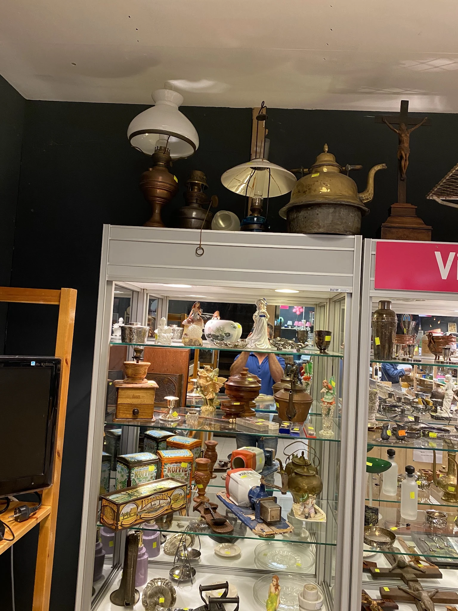 Vitrinekast met diverse huishoudelijke artikelen: koperen en metalen ketelwerk, servies en decoratieve objecten