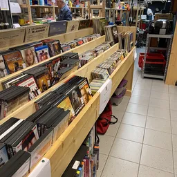 Houten stellingen met dvd's, blu-rays en cd's uitgestald in een kringloopwinkel