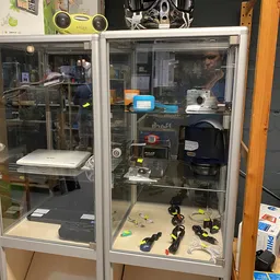 Glazen vitrinekasten met elektrische gereedschappen, gereedschapskisten en huishoudelijke apparaten