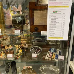 Vitrinekast met decoratieve items en een gelamificeerd prijslijst