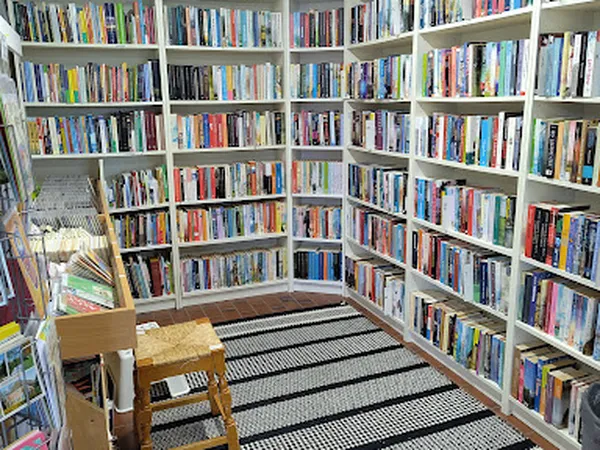 Boekenrekken langs de wanden van een kringloopwinkel met honderden dvd's en blu-rays netjes uitgestald
