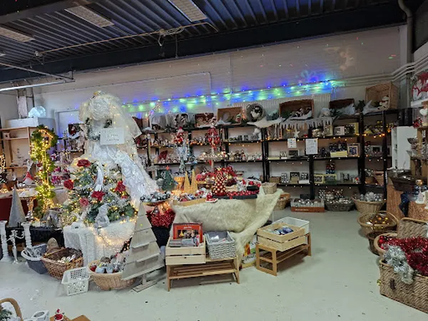 Winkelvloer met uitgestalde kerstdecoraties, bloemen en diverse artikelen op rekken tegen de muur